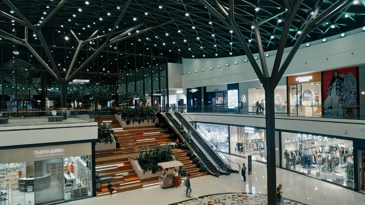 L'intérieur d'un centre commercial sur deux étages, boutiques de part et d'autre.